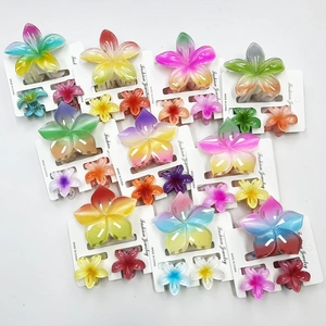 Macro detail of gradient plumeria hair claw clips in a vibrant two-piece set for women