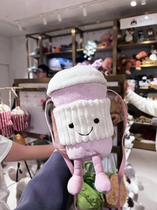 Close-up of a pink plush crossbody bag in a cute coffee cup shape with a smiling face