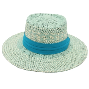 Détail d'un chapeau de paille vert menthe avec texture tissée et ruban bleu satiné