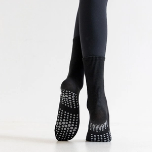 Detailed view of black non-slip yoga socks with grey hexagonal silicone grip dots