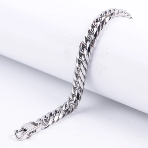 Close-up of a silver titanium steel Cuban link bracelet showing its polished lobster clasp