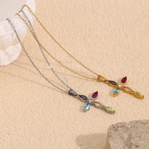Detailed macro view of 18K gold and silver cross necklaces with multicolor gemstones