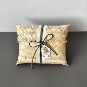 Macro view of handmade bamboo gift basket with green ribbon and pearl thank you tag