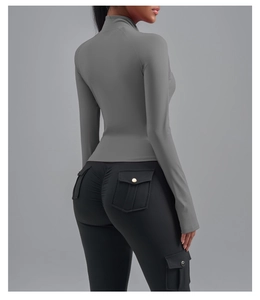 Détail d'une veste grise ajustée et de leggings noirs froncés avec poches cargo de sport
