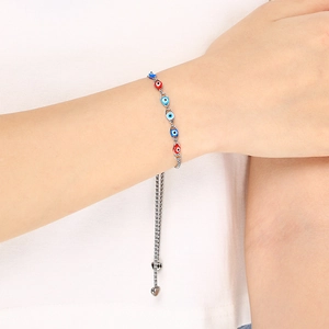 Silver chain bracelet featuring red and blue evil eye beads with an adjustable sliding clasp