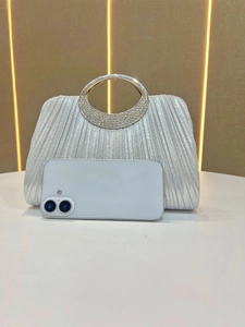 Silver pleated evening clutch bag with crystal ring handle and smartphone for size scale