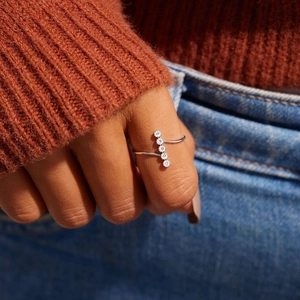 Close-up of a minimalist silver S925 ring featuring five small round-cut cubic zirconia stones
