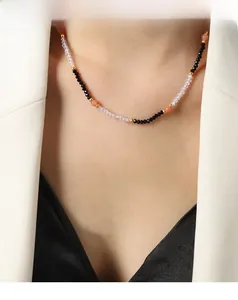 Detailed close-up of a handmade beaded necklace with black and orange faceted stones