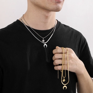 Detail view of layered gold and silver snake chains with star and moon pendants on model