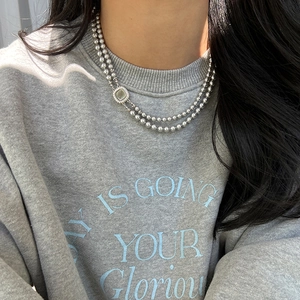 Close-up of double-layer beaded necklace with square pendant on model neck