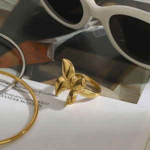 Detail of a gold butterfly-shaped stainless steel ring with elegant accessories