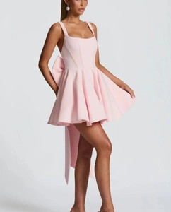 Detailed view of the large pink bow tie design on the back of a puffy short dress