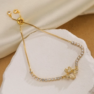 18K gold plated bee bracelet with sparkling zircons on a white textured stone base
