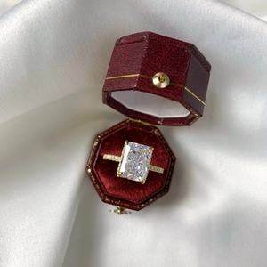 Macro detail of radiant ice-cut rectangle zircon ring in luxury red jewelry box