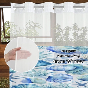 Detail of semi-sheer ocean themed shower curtain with metal rings and seashell prints