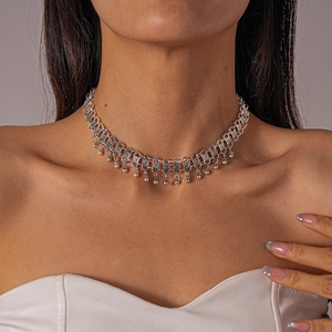 Detail of silver choker with intricate hollow metal mesh and dangling spherical beads