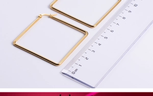 Detailed view of large gold square titanium steel hoop earrings showing 5cm size scale