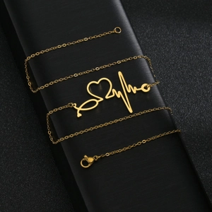 Gold ECG heartbeat necklace with stethoscope heart pendant on black display box