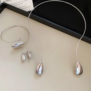 Polished silver teardrop jewelry set with necklace collar, open cuff, and stud earrings