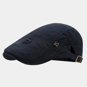 Detail of the navy cotton newsboy cap with embroidery and adjustable bronze buckle