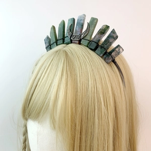 Detailed close-up of a handmade green crystal crown with moon charm on a black headband