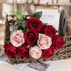 Close-up of deep red and light pink artificial silk roses in a woven basket