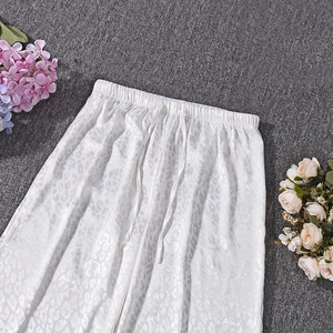 Detailed close-up of white leopard print casual pants with elastic drawstring waist