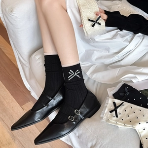 Détails de chaussettes noires en coton avec nœuds blancs et maille côtelée fine