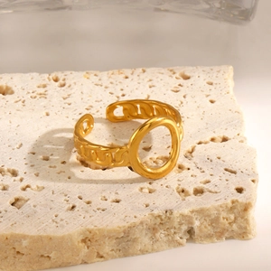 Golden open chain ring with large oval circle design on natural stone background