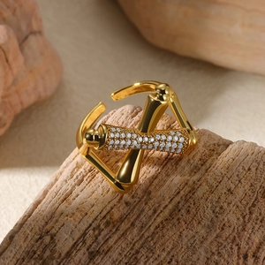 Detail of gold open ring featuring geometric crossover design and pavé zircon stones