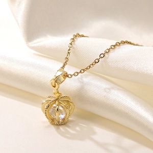 Elegant gold crown pendant necklace with round clear zircon on white silk background