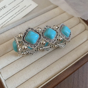 Macro detail of vintage silver-tone stretch bracelet with square turquoise-style stones