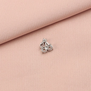 Macro detail of a cherry-shaped stainless steel pendant base with two round settings