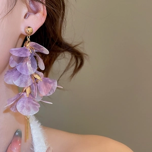 Detail of lavender mesh flower earrings with gold tassel dangling on model