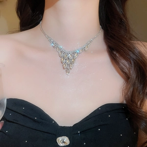 Close-up of elegant V-shaped tassel necklace with sparkling crystals on a black dress