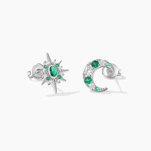 Macro view of asymmetrical 925 silver star and moon earrings with green and white zircons