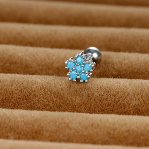 Detail of silver flower stud earring with turquoise stones on brown velvet stand