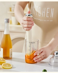 Action shot of the white muddler crushing orange slices in a 500ml scaled plastic beaker