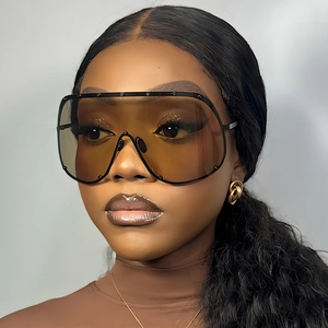 Oversized amber tinted shield sunglasses with black studded frame on fashion model