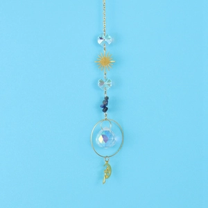Close-up of golden sun and crescent moon suncatcher with crystal prisms and blue stones