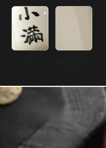 Macro detail of hand-painted calligraphy on vintage ash-glazed ceramic tea canister