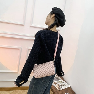 Pink monogram cylinder shoulder bag for women worn by a model in a minimalist setting