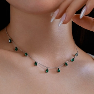Close-up of S925 silver necklace featuring green pear-shaped cubic zirconia on a model