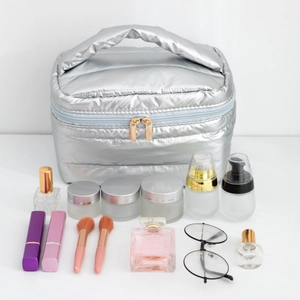 Sleek silver puffy cosmetic bag with dual gold zippers and wide top handle