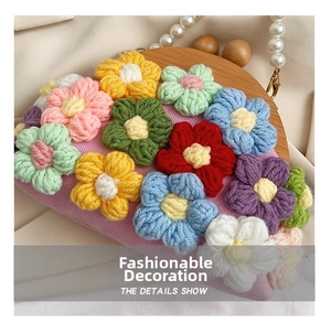 Detailed shot of handmade crochet flowers and wooden clasp on the shell bag