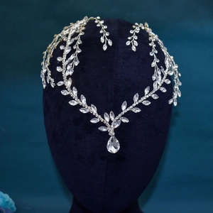Close-up of bridal headband with silver leaf details and water drop rhinestone pendant