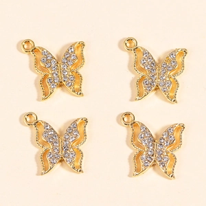 Close-up of four golden butterfly pendants with sparkling rhinestones for jewelry making