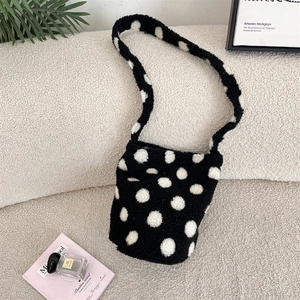 Sac seau en peluche à pois présenté dans un décor élégant avec décoration artistique