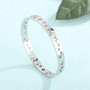 Silver hollow star pattern bangle in 18K gold plated stainless steel on blue background