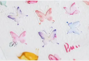 Macro close-up of semi-transparent butterfly nail stickers with watercolor art details